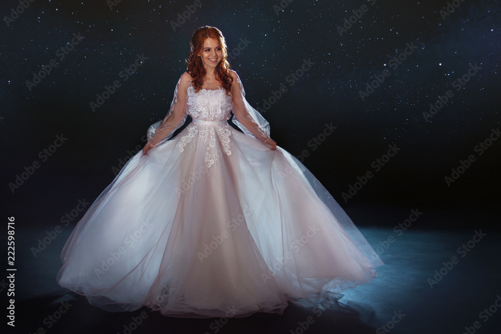 Fabulous bride in a beautiful dress among the stars. Young beautiful woman in wedding dress with wide light skirt Fabulous bride in a beautiful dress among the stars. Young beautiful woman in wedding dress with wide light skirt