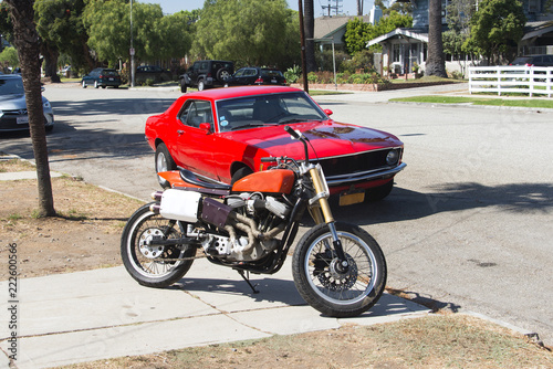 A vintage motorcycle and a car in the street in Venice, California