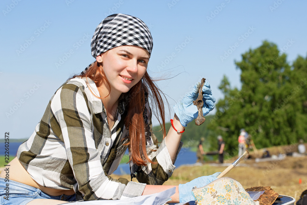 Girl archaeologist demonstrates the find during the field expedition