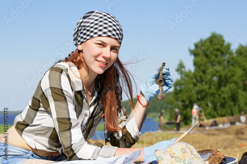 Obraz na płótnie Girl archaeologist demonstrates the find during the field expedition w salonie