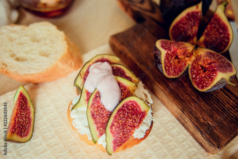 Autumn dessert: bruschetta with ripe figs, soft cheese and honey on a light background. Autumn dessert: bruschetta with ripe figs, soft cheese and honey on a light background.