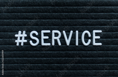 Hashtag word #service written on the letter board. White letters on the black background.
