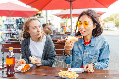 Photography Woman eating Currywurst fast food German sausage in outdoor street food cafe