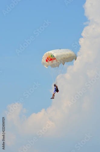 Parachute jumper skydiving on the clouds on daylight
