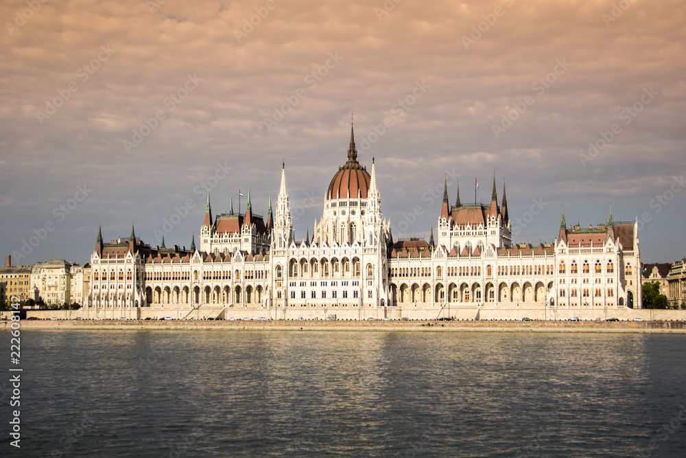 Fototapeta premium Parliament building in Budapest with clouds and water reflection at golden hour