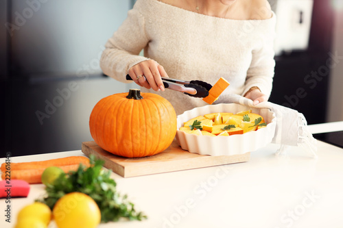 Adult woman in the kitchen preparing pumpkin dishes for Halloween