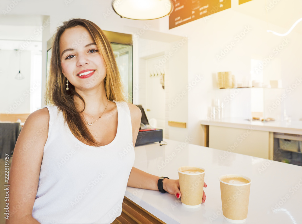 Beauty portrait of young women enjoy coffee in coffee shop on wooden table. Fascinating fashion model posing Beauty portrait of young women enjoy coffee in coffee shop on wooden table. Fascinating fashion model posing