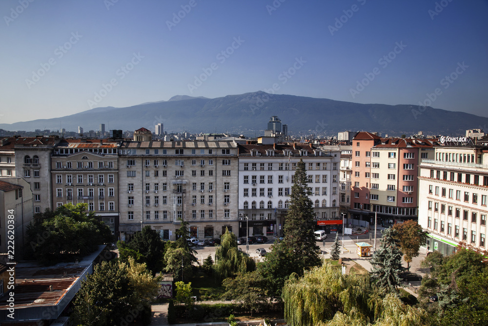 Obraz premium Aerial view of East European City. Many buildings with a mountain background. Urban sprawl. Rila hotel view. Bulgaria, Sofia - September 1, 2018