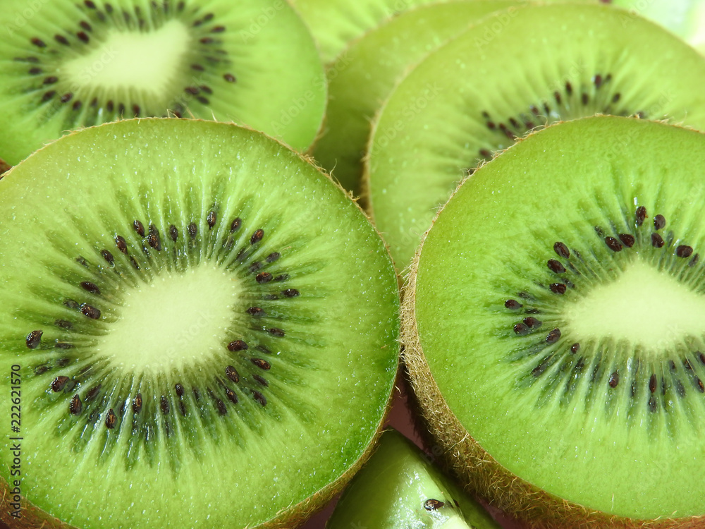 Close up texture of ripe fresh oval kiwifruits in different shapes.It has fibrous, bright green flesh and edible black seeds.A sweet and unique taste.It is a natural, healthy and nutritious food.