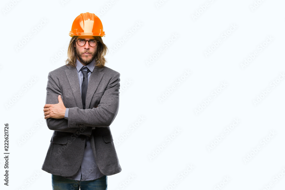 Young handsome architec man with long hair wearing safety helmet over isolated background skeptic and nervous, disapproving expression on face with crossed arms. Negative person.