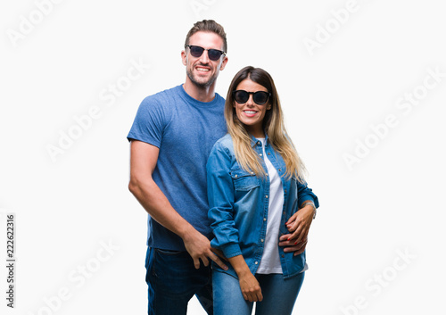 Young couple in love wearing sunglasses over isolated background with a happy and cool smile on face. Lucky person.