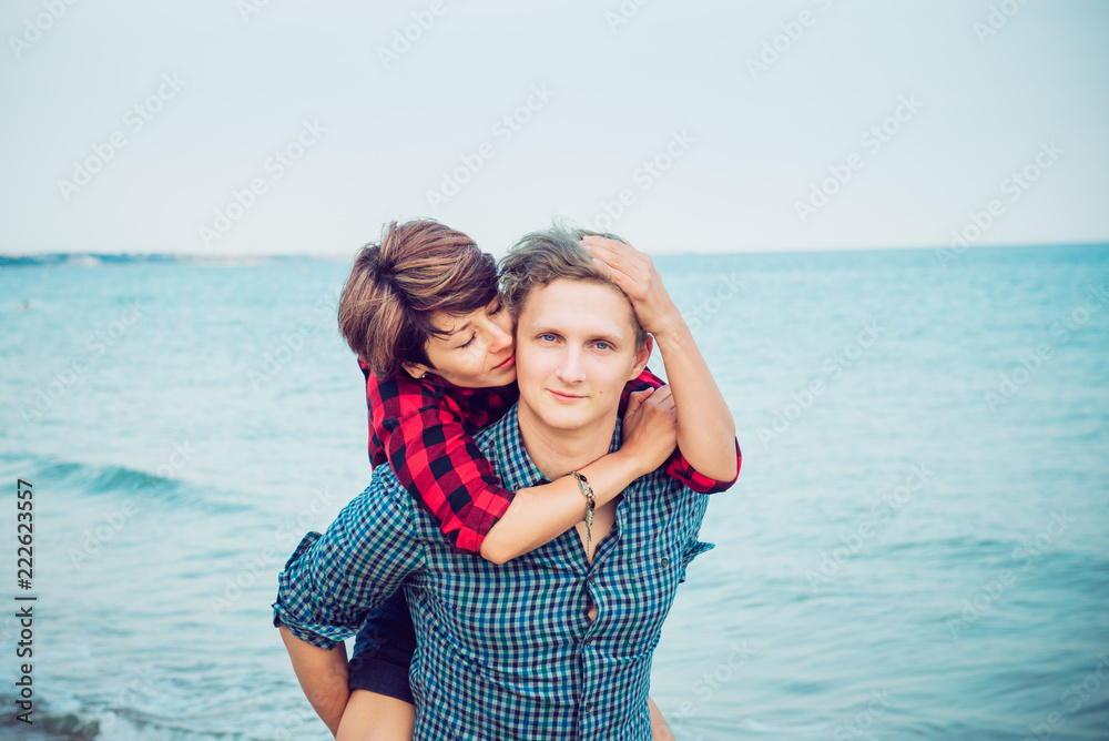 Portraits of happy romantic couple on the sea beach embracing each other. Concept of lovers happy moments on holiday, vacation. Tenderness love story concept. Selective focus. Copy space. Portraits of happy romantic couple on the sea beach embracing each other. Concept of lovers happy moments on holiday, vacation. Tenderness love story concept. Selective focus. Copy space.