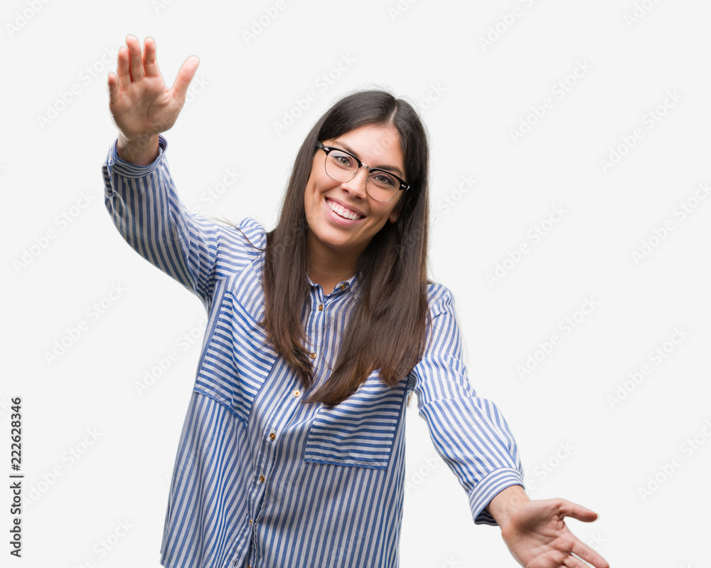 Young beautiful hispanic business woman looking at the camera smiling with open arms for hug. Cheerful expression embracing happiness. Young beautiful hispanic business woman looking at the camera smiling with open arms for hug. Cheerful expression embracing happiness.