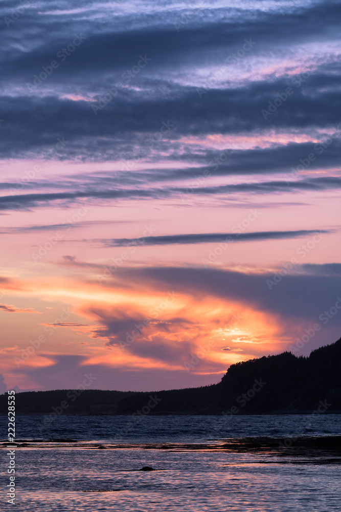 Sunset over Rocky Harbour in Newfoundland with the Lobster Cove Lighthouse in the distant background Sunset over Rocky Harbour in Newfoundland with the Lobster Cove Lighthouse in the distant background