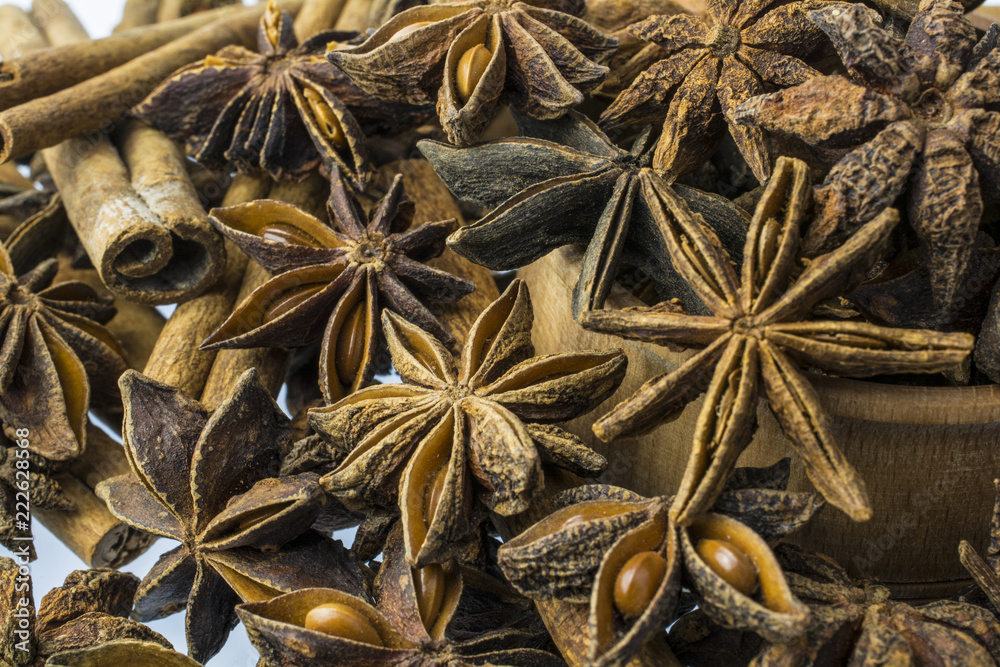 Sticks of cinnamon and various whole asterisks of anise by close-up.