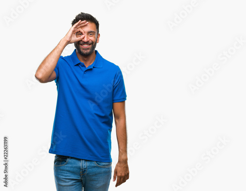 Adult hispanic man over isolated background doing ok gesture with hand smiling, eye looking through fingers with happy face.