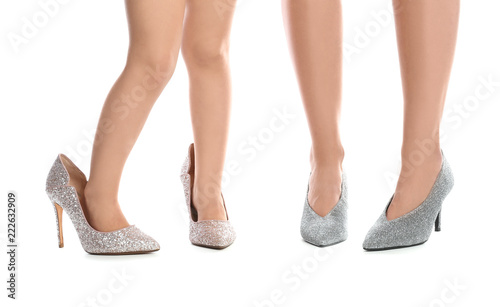 Mother and daughter in high heeled shoes on white background, closeup on legs