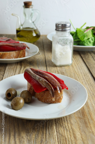 Spanish tapa - slice of bread with roasted red pepper, anchovy and olive oil