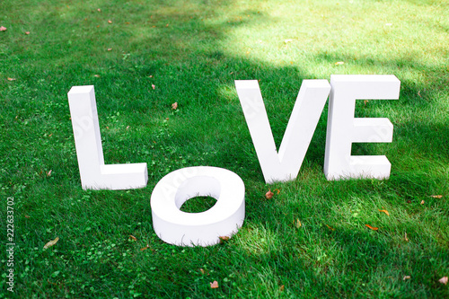 White big love letters on the green grass in the park
