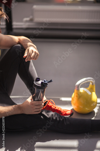 Male athlete preparing for workout with kettlebells in gym. Male athlete getting ready for training. Sportboots and active lifestyle concept. Close-up photo