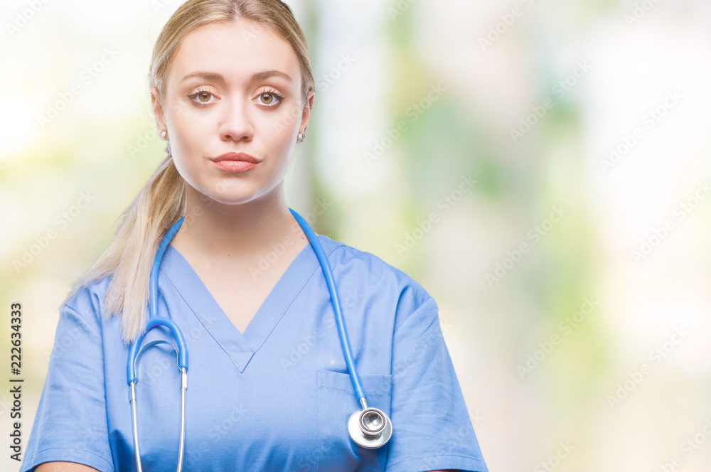 Young blonde surgeon doctor woman over isolated background with serious expression on face. Simple and natural looking at the camera. Young blonde surgeon doctor woman over isolated background with serious expression on face. Simple and natural looking at the camera.
