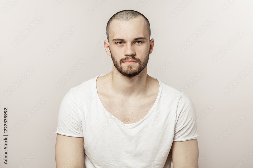 Attractive brutal man in white T-shirt looking at the camera. sport, people, beauty concept. isolated white background. Attractive brutal man in white T-shirt looking at the camera. sport, people, beauty concept. isolated white background.