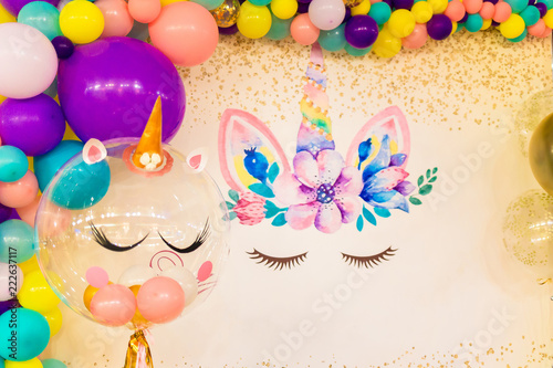 Bright unicorn and many multi-colored balloons. Party decor photo