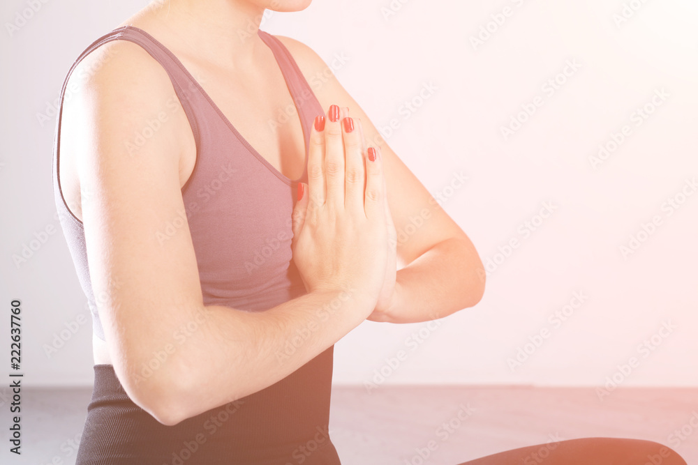 Yoga girl meditating. Young female doing exercise on gray background.  Toned