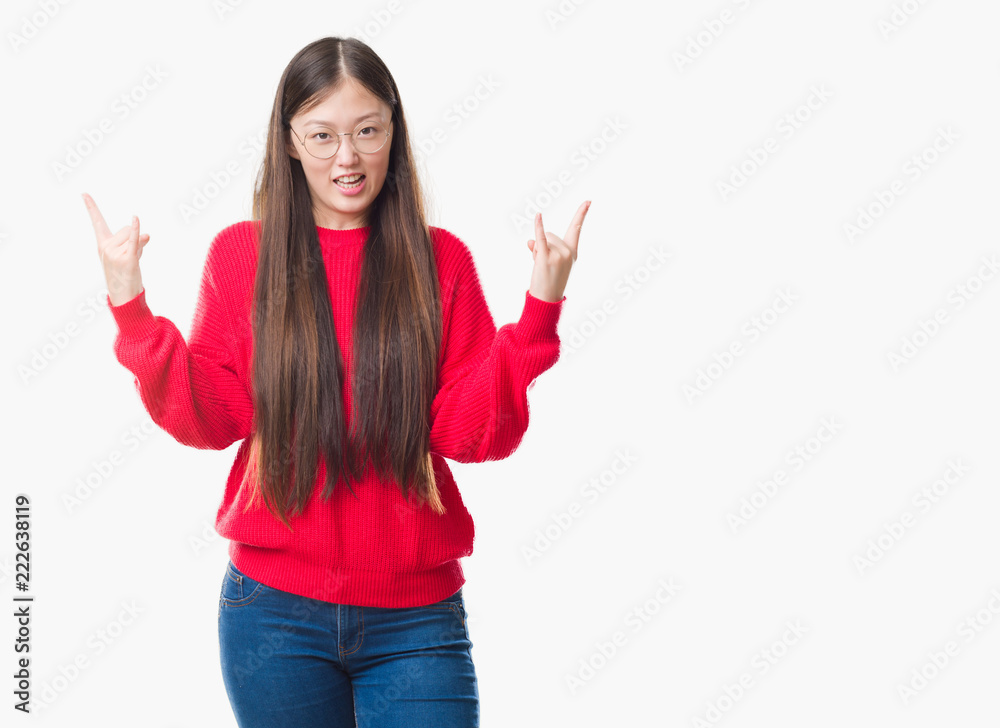Young Chinese woman over isolated background wearing glasses shouting with crazy expression doing rock symbol with hands up. Music star. Heavy concept. Young Chinese woman over isolated background wearing glasses shouting with crazy expression doing rock symbol with hands up. Music star. Heavy concept.