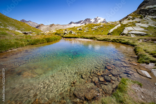 beautifully green and aqua colored mountain lake with views of mountain peaks