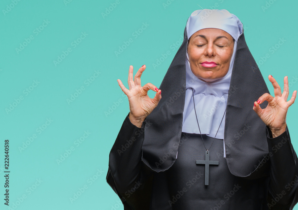 Middle age senior christian catholic nun woman over isolated background relax and smiling with eyes closed doing meditation gesture with fingers. Yoga concept. Middle age senior christian catholic nun woman over isolated background relax and smiling with eyes closed doing meditation gesture with fingers. Yoga concept.