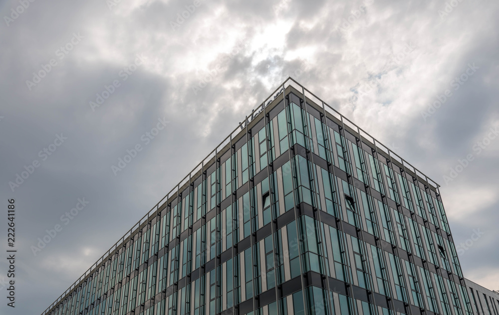 Glass office building close up shot , rain clouds on the background.