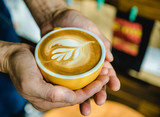 Barista pouring milk in coffee cup .