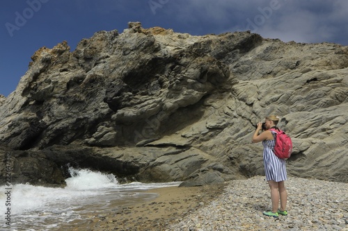 Frau fotografiert bizarre Felsküste auf einer griechischen Insel in der Ägäis