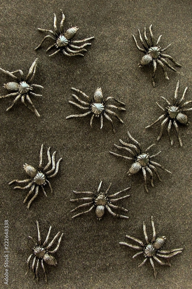 Black rubber spider toys on velvet background. Dark halloween october concept.