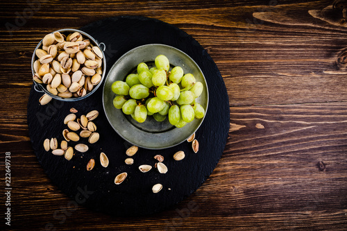 Pistachios and grapes on wooden table
