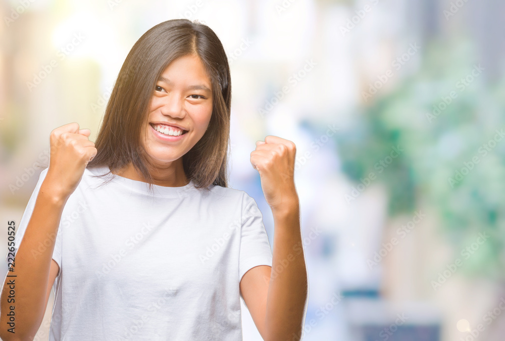 Young asian woman over isolated background very happy and excited doing winner gesture with arms raised, smiling and screaming for success. Celebration concept. Young asian woman over isolated background very happy and excited doing winner gesture with arms raised, smiling and screaming for success. Celebration concept.