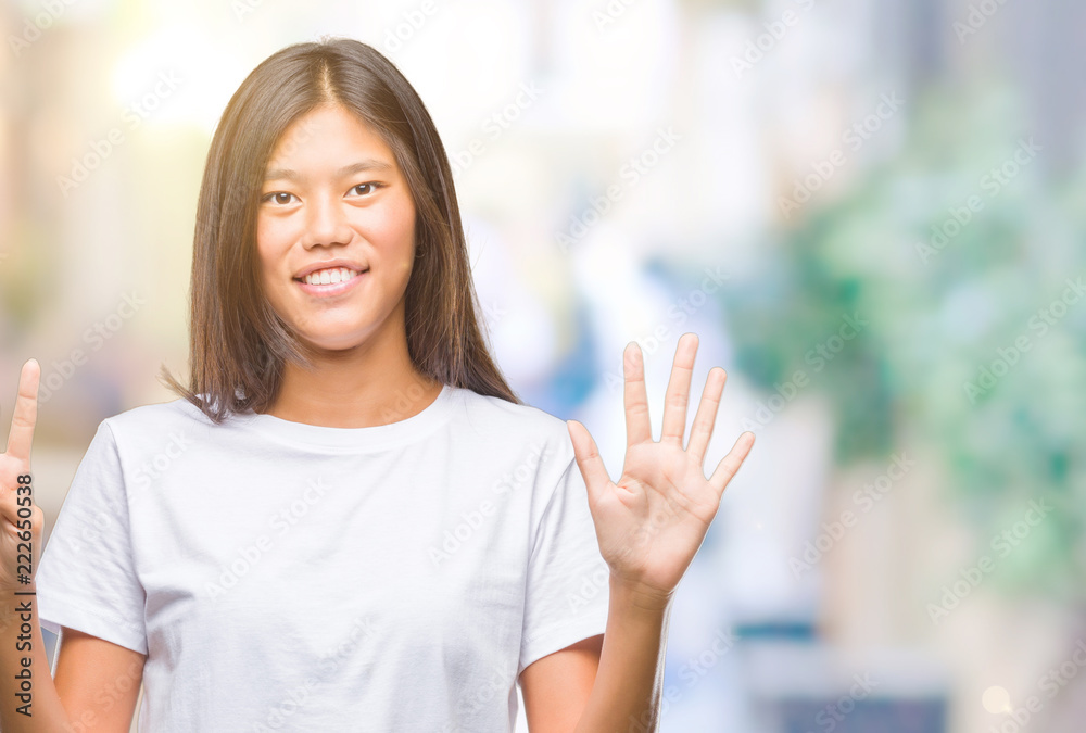 Young asian woman over isolated background showing and pointing up with fingers number nine while smiling confident and happy.