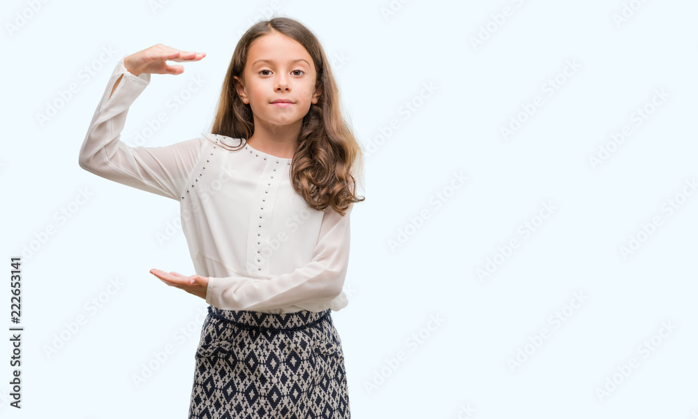 Brunette hispanic girl gesturing with hands showing big and large size sign, measure symbol. Smiling looking at the camera. Measuring concept. Brunette hispanic girl gesturing with hands showing big and large size sign, measure symbol. Smiling looking at the camera. Measuring concept.
