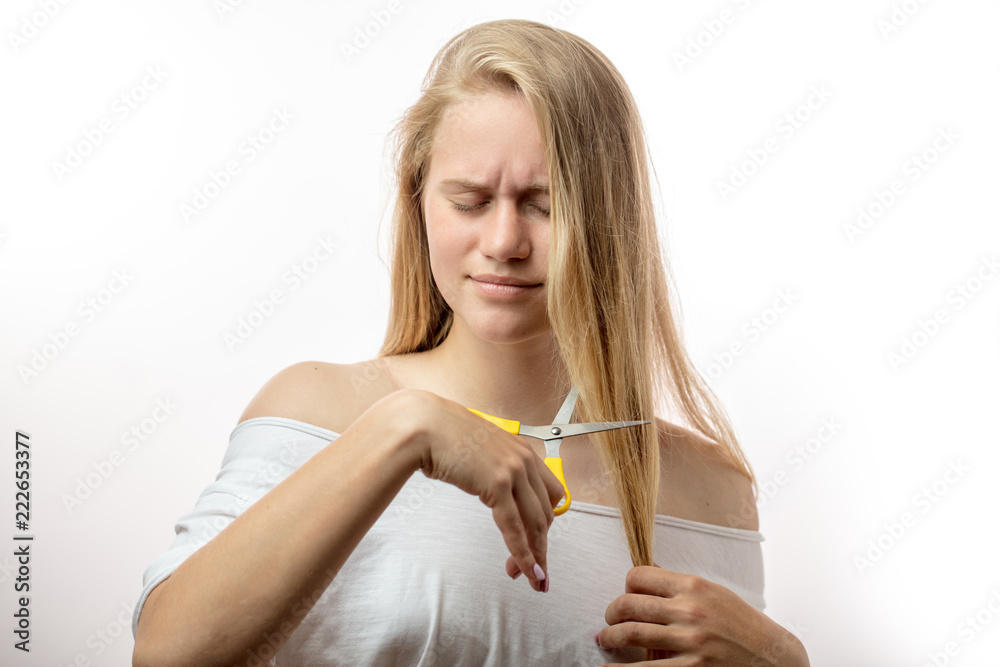 Unhappy attractive young woman with long blonde hair holding scissors in  hands, noticed split ends, going to cut off the ends. Human face expression  emotion. Beauty hairstyle concept Stock Photo | Adobe