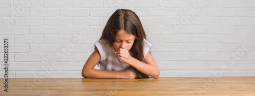 Canvastavla Young hispanic kid sitting on the table at home feeling unwell and coughing as symptom for cold or bronchitis