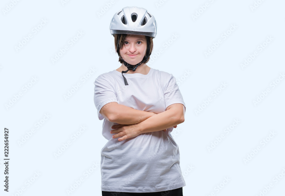 Young adult cyclist woman with down syndrome wearing safety helmet over isolated background happy face smiling with crossed arms looking at the camera. Positive person. Young adult cyclist woman with down syndrome wearing safety helmet over isolated background happy face smiling with crossed arms looking at the camera. Positive person.