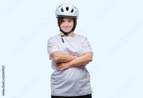 Young adult cyclist woman with down syndrome wearing safety helmet over isolated background happy face smiling with crossed arms looking at the camera. Positive person. © Krakenimages.com