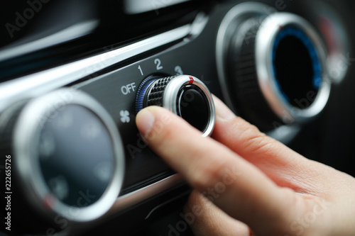 Adjust air conditioner on dashboard in the car.