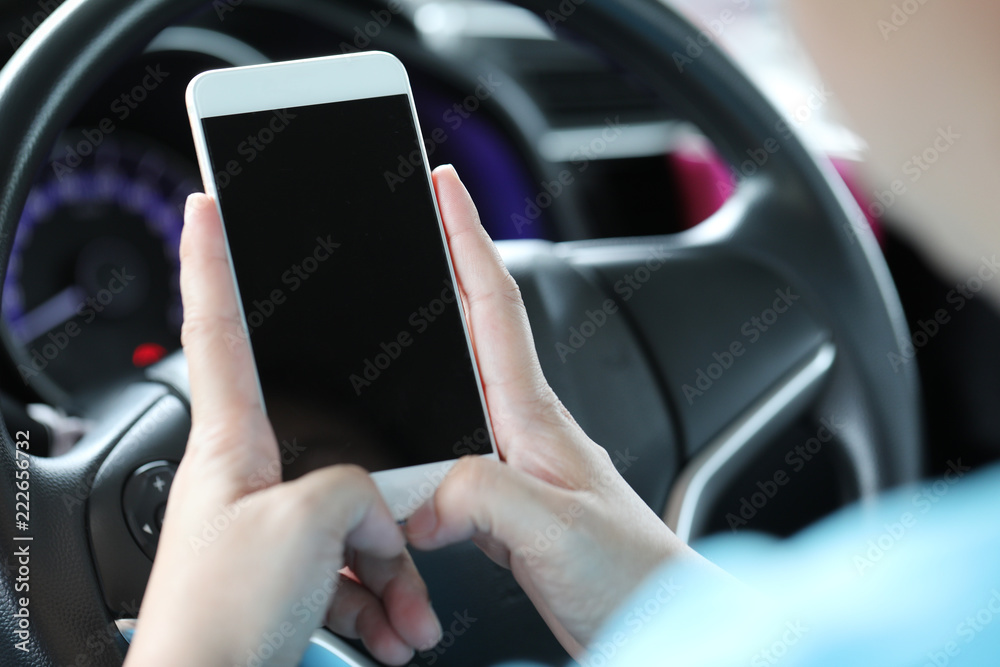 Woman using mobile phone in the car.