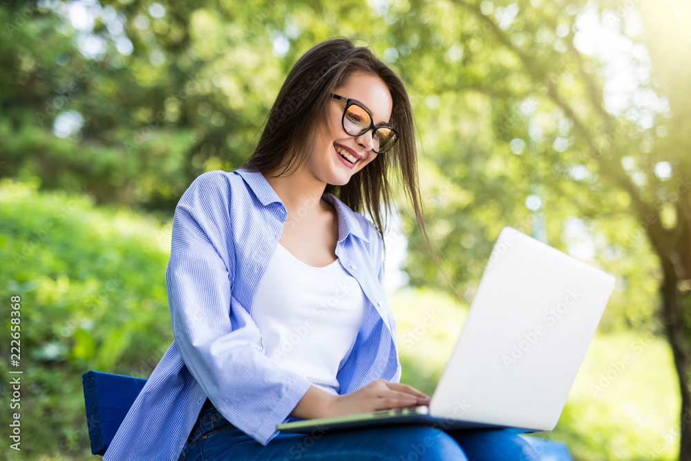 Young student Girl in eyesglasses resting and relaxing in the park and laptop. Young student Girl in eyesglasses resting and relaxing in the park and laptop.