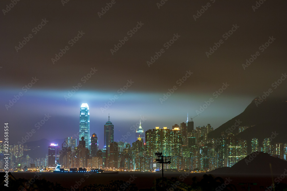 Storm Clouds hanging over Skyline of Hong Kong Central District with IFC Tower lighting the sky