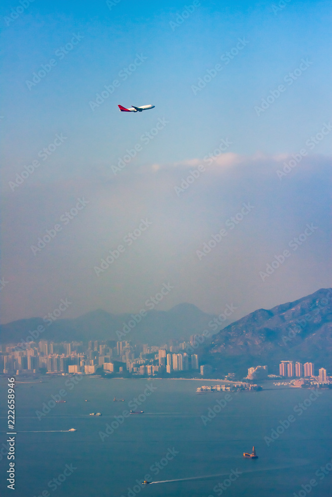 Hong Kong Skyline with Airplane Taking off in Foreground Hong Kong Skyline with Airplane Taking off in Foreground