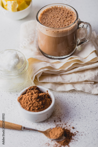 BULLETPROOF CACAO. Ketogenic keto diet hot drink. Cacao blended with coconut oil and butter. Cup of bulletproof cacao and ingredients on white background photo