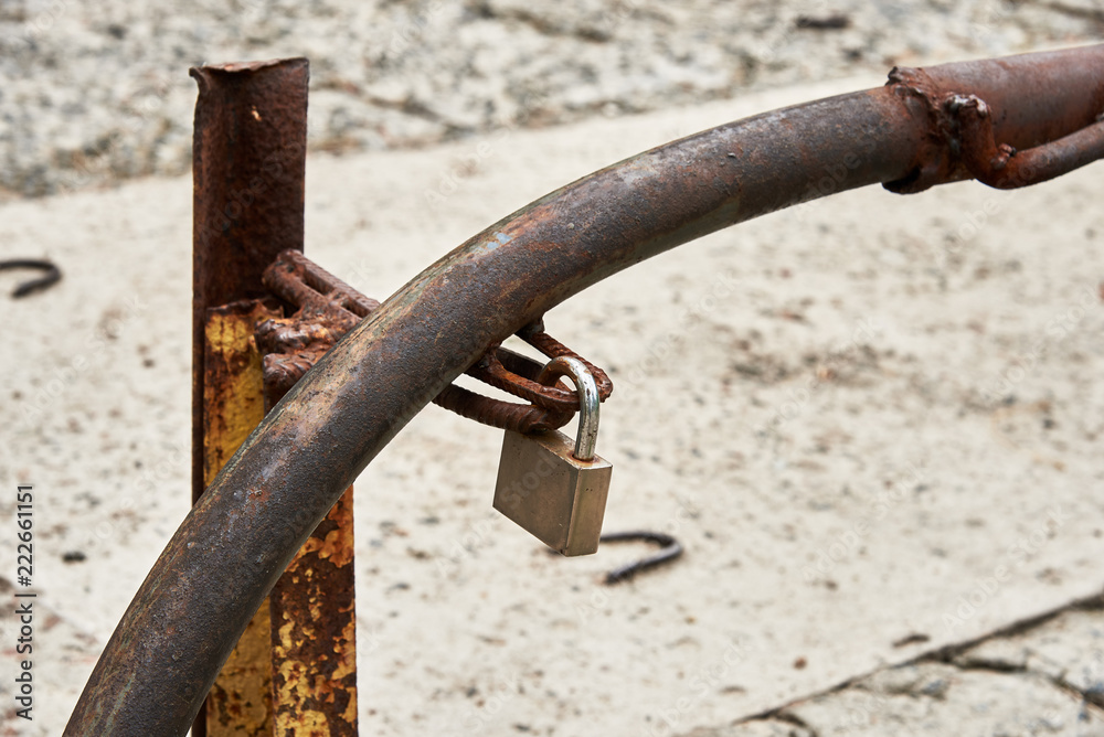 Rusty barrier is closed on a padlock Rusty barrier is closed on a padlock